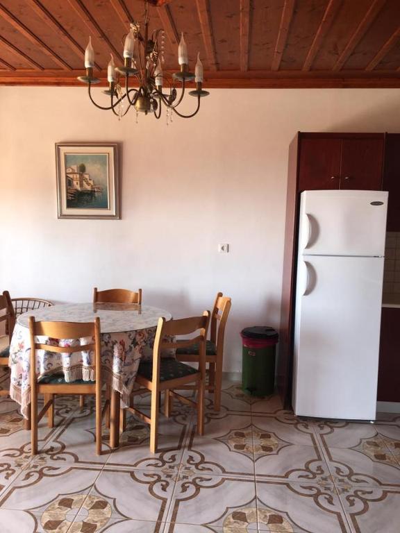 a kitchen with a table and a white refrigerator at Princess Studios in Afiartis