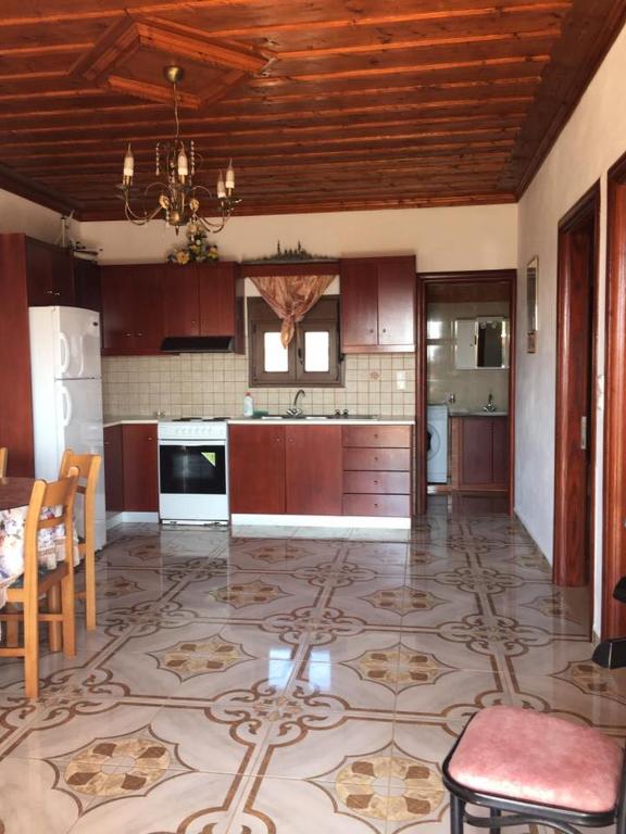 a kitchen with brown cabinets and a tile floor at Princess Studios in Afiartis