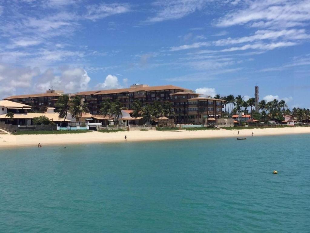 a resort on a beach with the ocean and a building at Barra Bali Barra in Barra de São Miguel