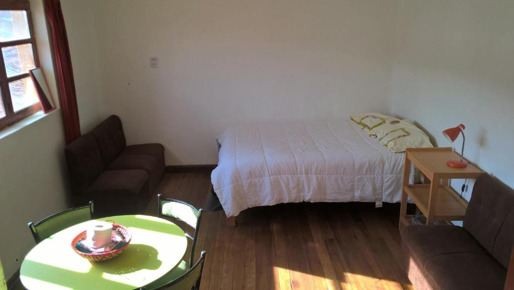 um quarto com uma cama, uma mesa e um sofá em Studio in historic center Cusco em Cusco
