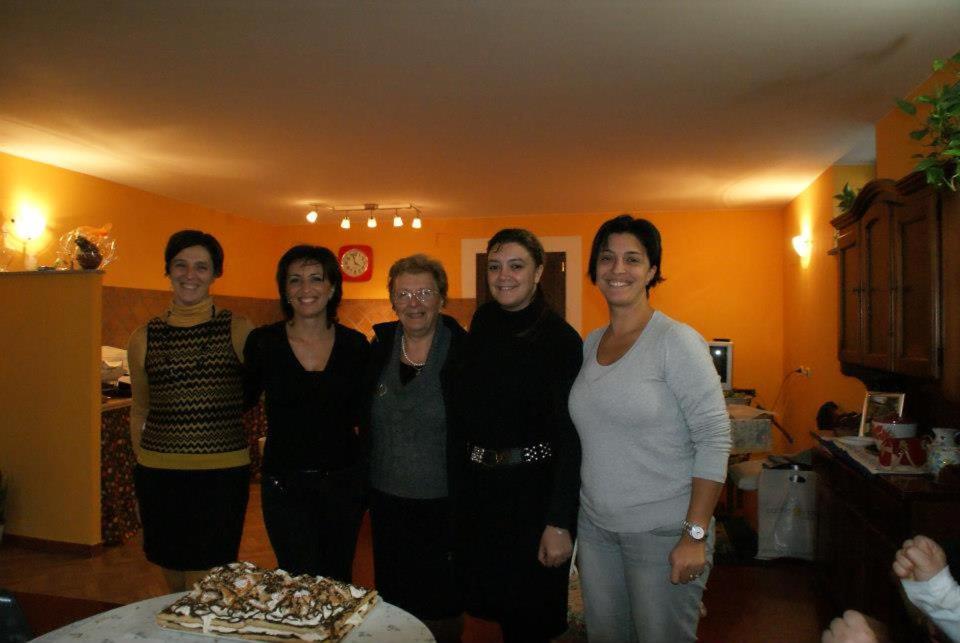 um grupo de mulheres em pé na frente de um bolo em Bed&Breakfast degli ulivi em Fiano Romano