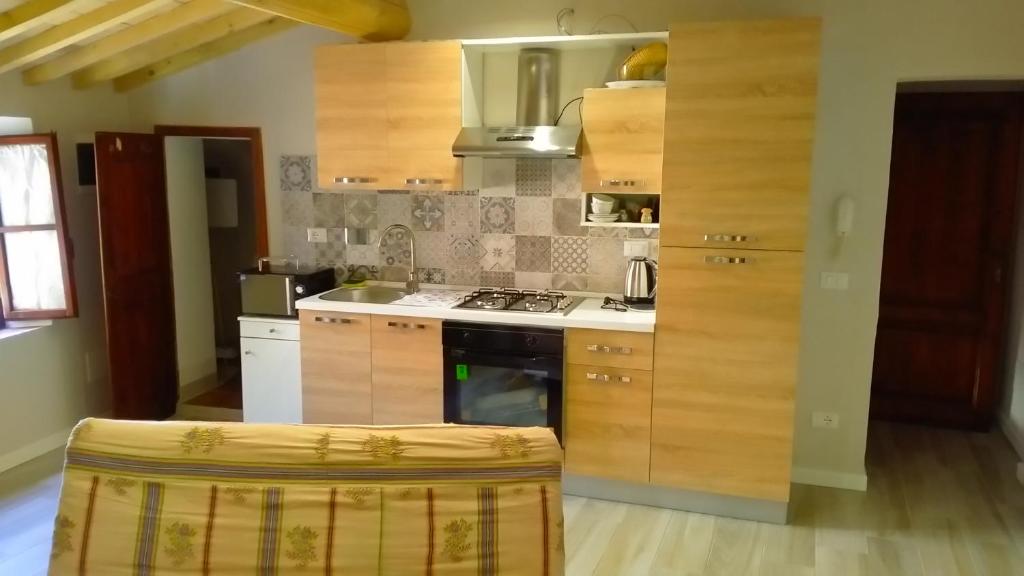 a kitchen with wooden cabinets and a stove top oven at Casa Maria Teresa in San Donato in Poggio