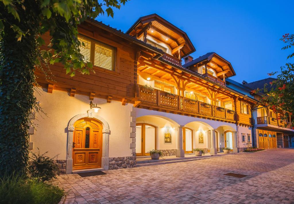 a large house with wooden doors and a patio at Apartment Ledrar in Bled