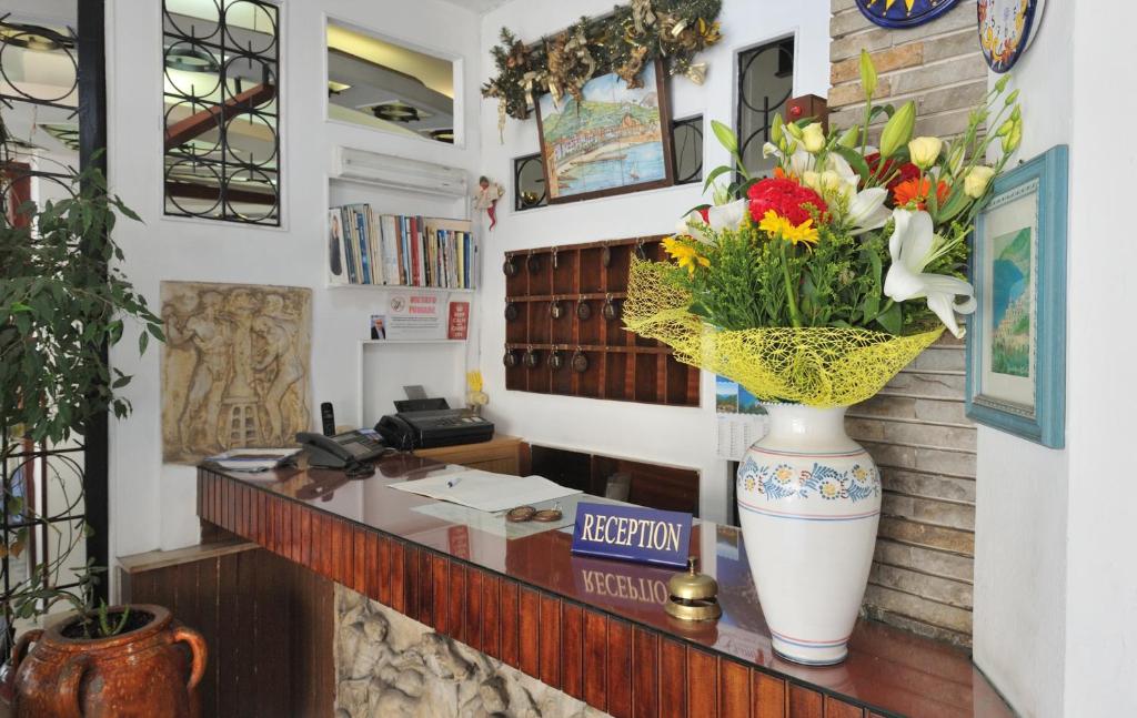 a lobby with a vase of flowers on a counter at Hotel Europa in Minori