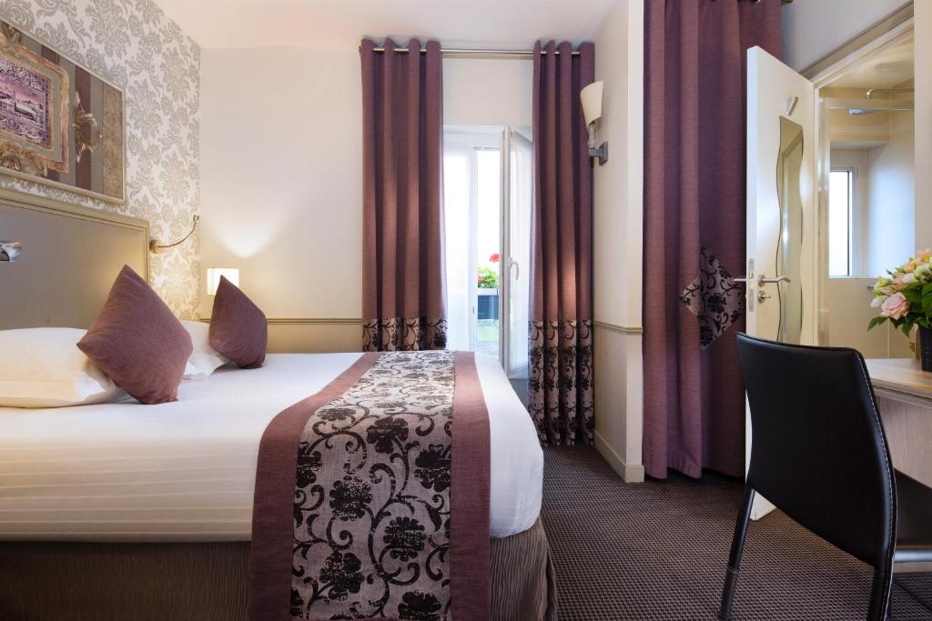 a hotel room with two beds and two lamps at Hotel Monceau Wagram in Paris