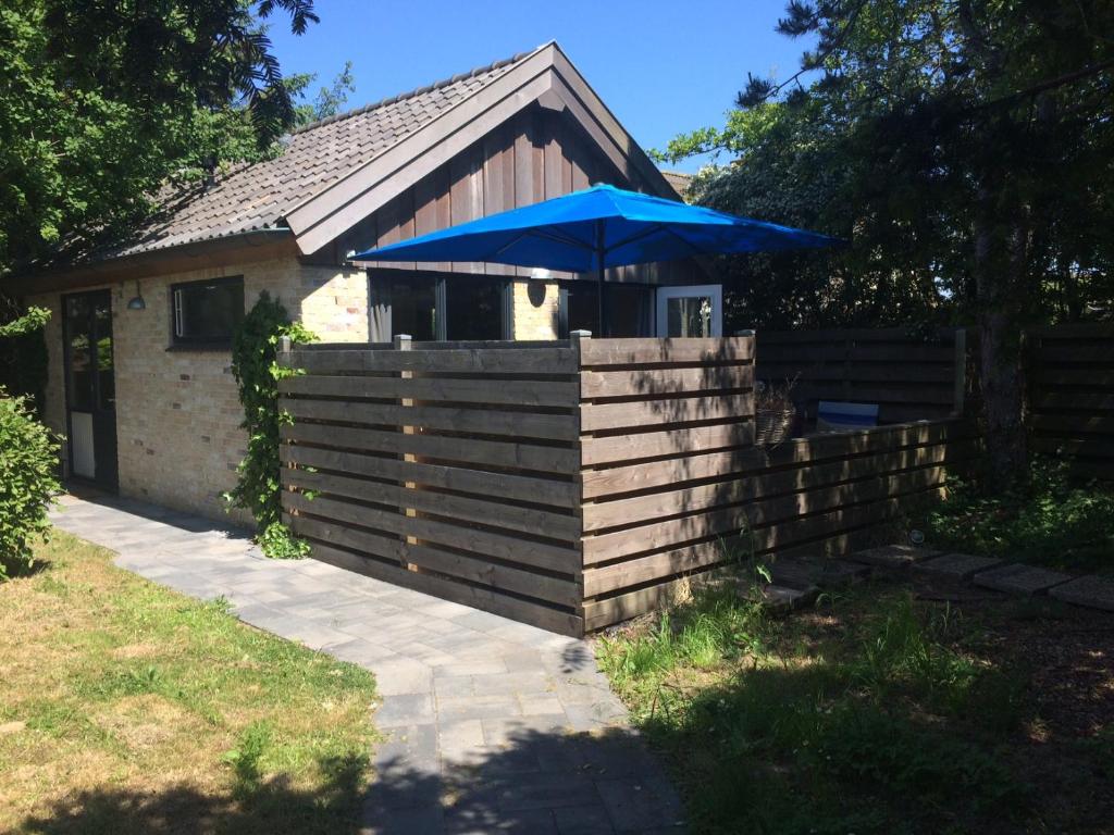 una casa con un paraguas azul en una valla en Texelduinen59, en De Koog
