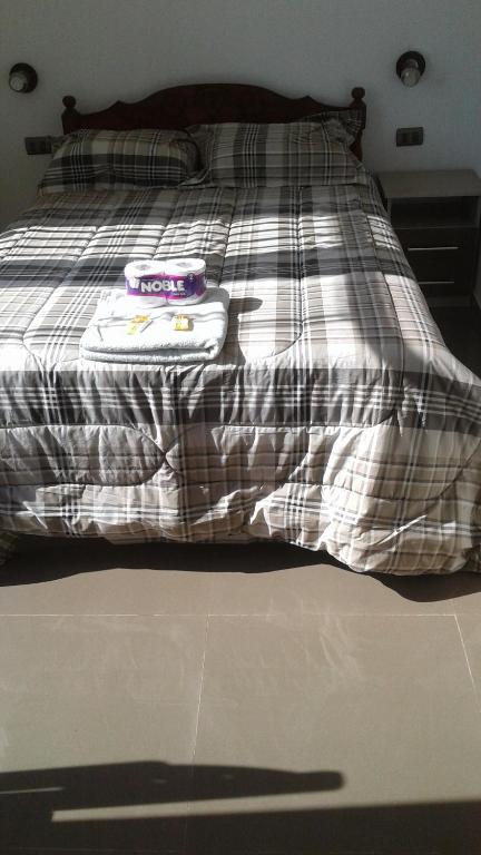 Una cama con una manta y dos toallas. en Chicama Surf Camp, en Puerto Chicama