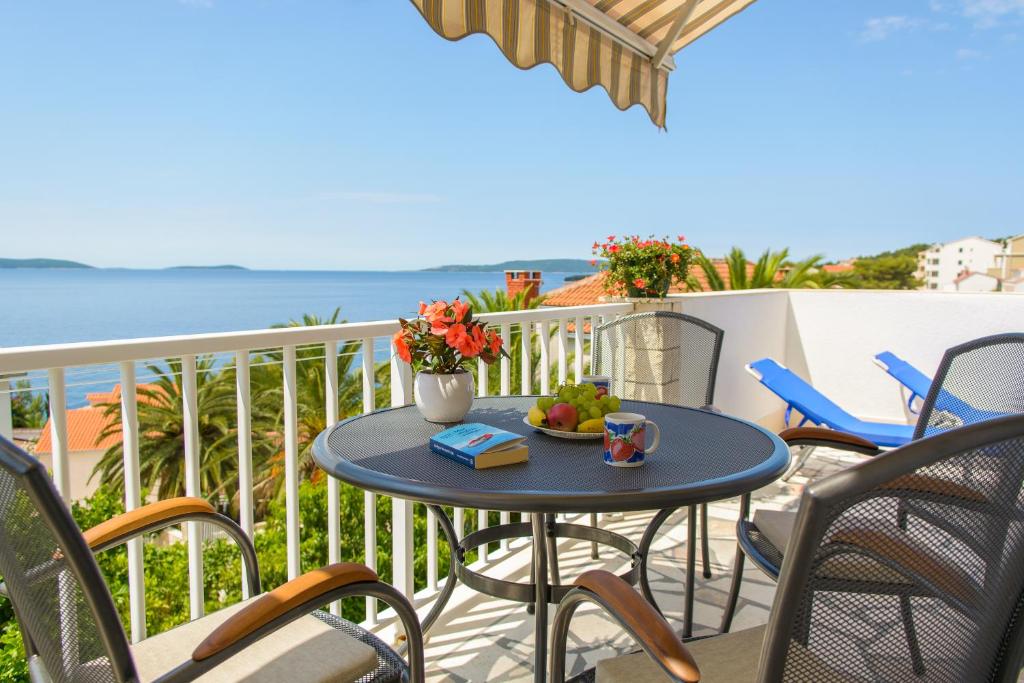 d'une table et de chaises sur un balcon donnant sur l'océan. dans l'établissement Apartments Klasan, à Trogir