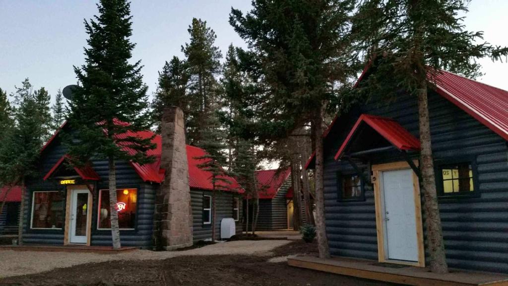 una casa blu con tetto rosso e alberi di Yellowstone Cabins and RV a West Yellowstone