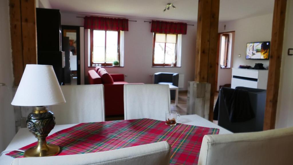 a dining room table with a lamp and a living room at Domek nad Złotym Potokiem in Szklarska Poręba