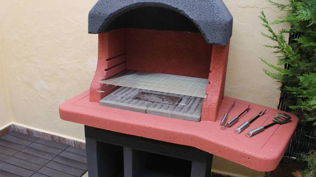 a red bench with a grill on a patio at Casa Coromines in Alcudia