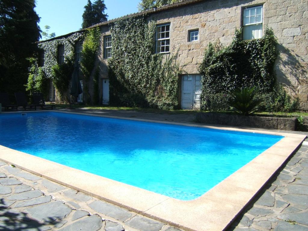 einem blauen Pool vor einem Gebäude in der Unterkunft Quinta de Bóco in Arouca
