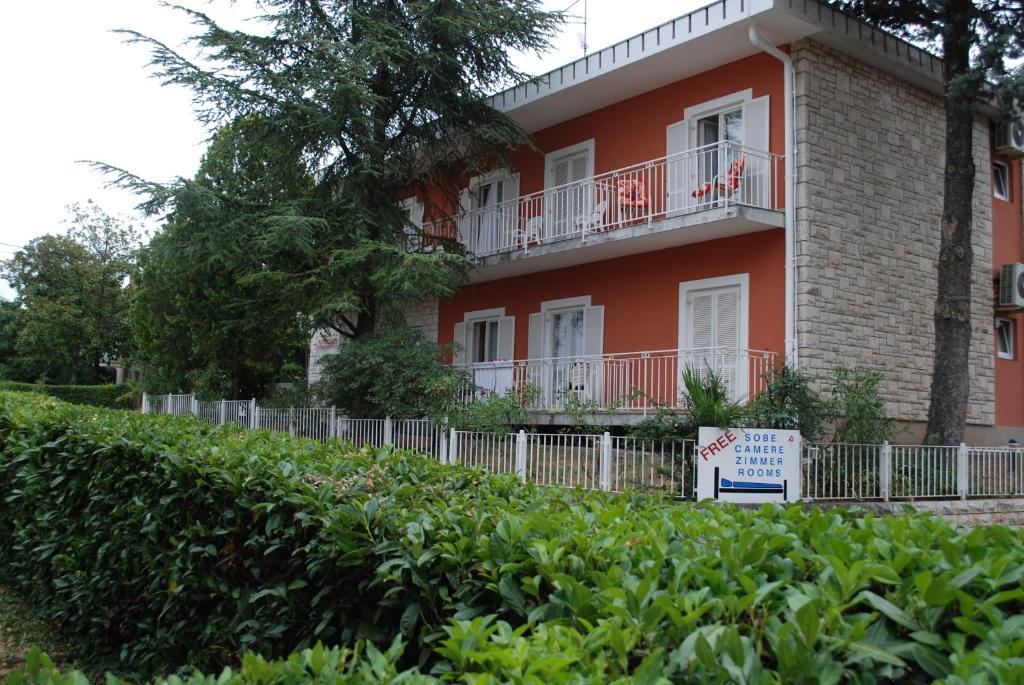 ein rotes Gebäude mit einem Schild davor in der Unterkunft Bed and Breakfast La Rossa in Umag