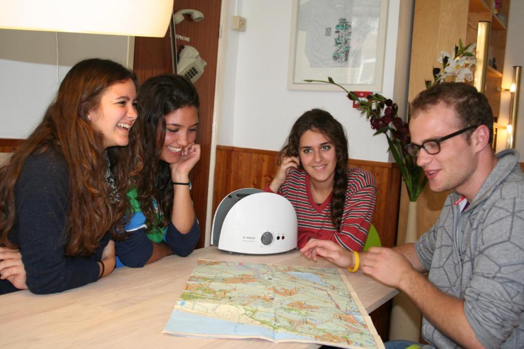 un grupo de personas sentadas en una mesa mirando un mapa en Bicycle Hotel Amsterdam en Ámsterdam