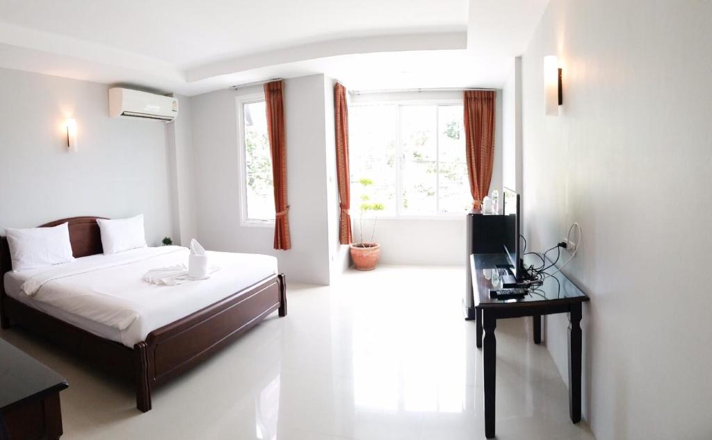 um quarto branco com uma cama e uma janela em J.Holiday Inn Krabi em Krabi
