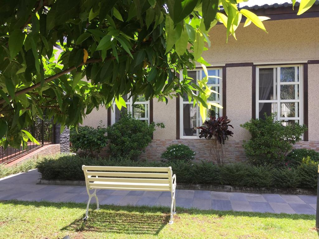 a bench sitting in the grass in front of a house at Champs Yazuh B&amp;B in Jiji