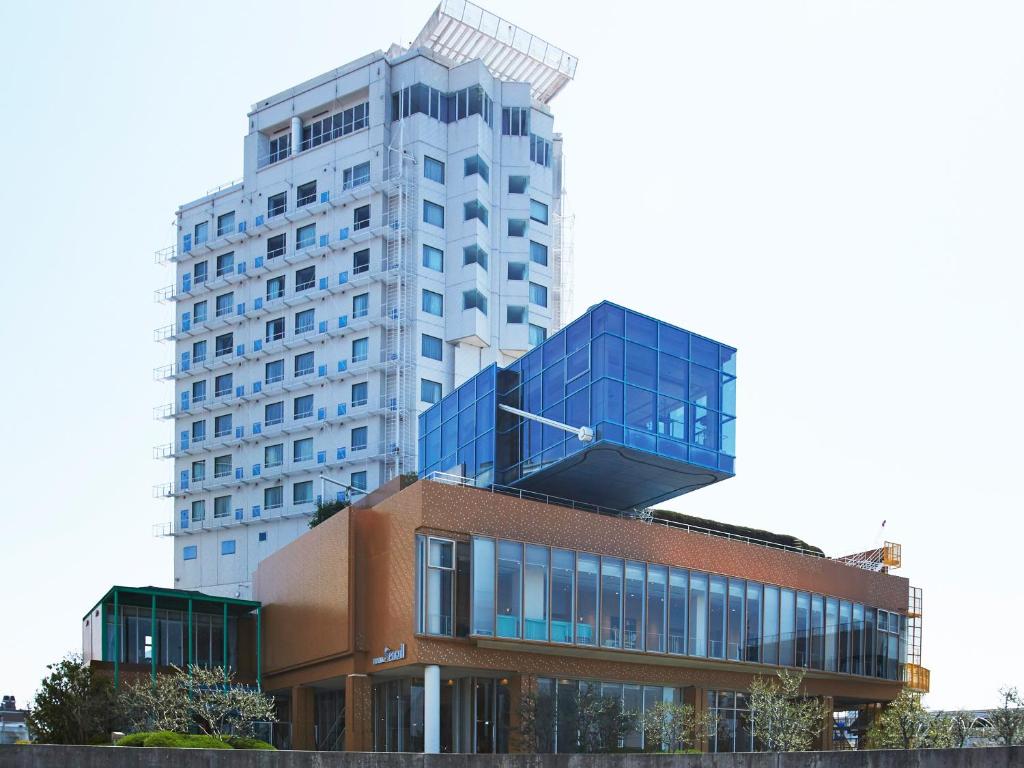 大阪市にあるホテルシーガルてんぽーざん大阪のレンガ造りの背後に高層ビル
