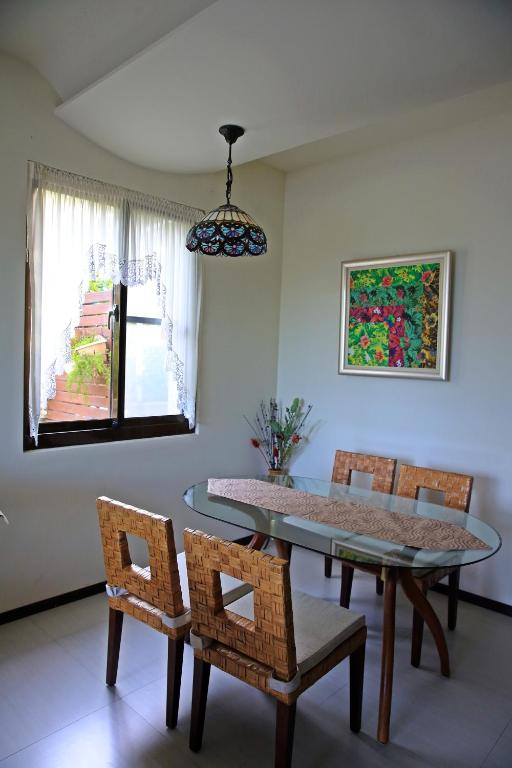 a dining room with a glass table and chairs at La View 麗晨 Homestay in Manzhou