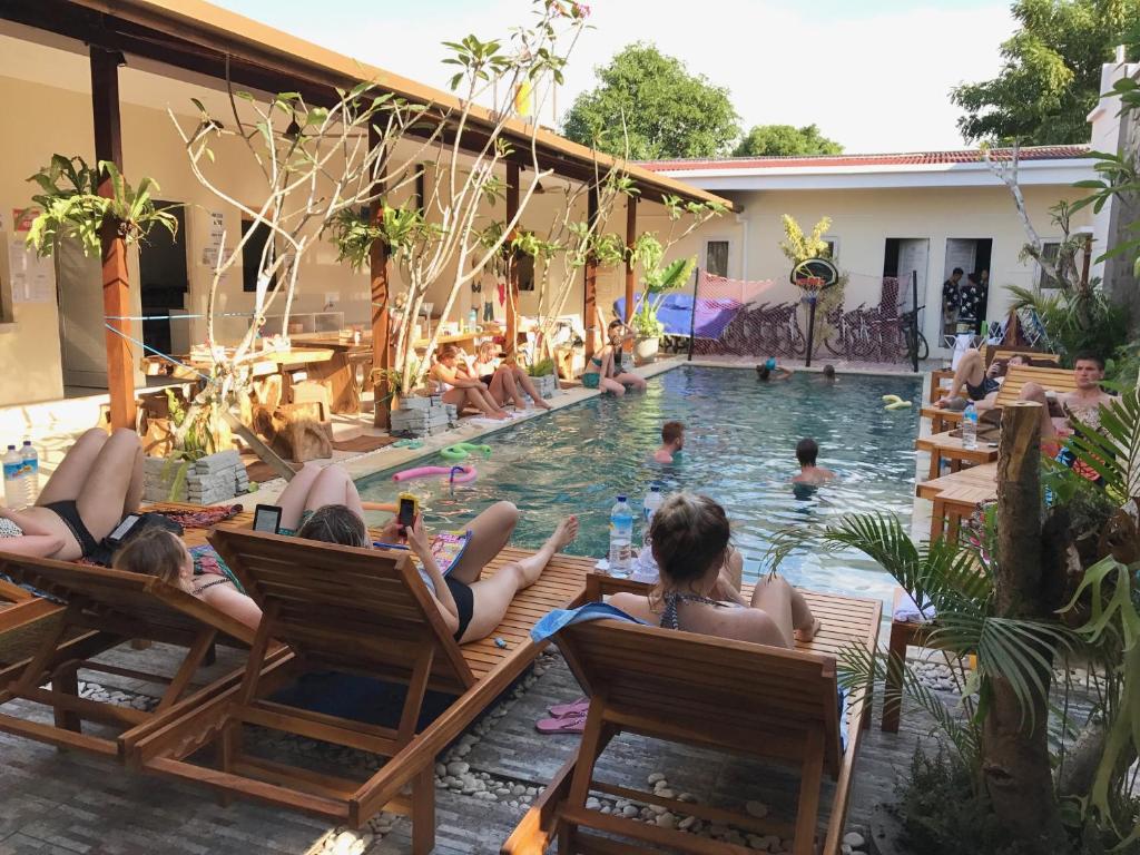 un grupo de personas tumbadas en sillas en una piscina en M BOX Gili Trawangan, en Gili Trawangan