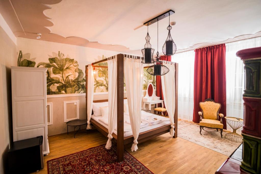 a bedroom with a canopy bed and a chair at Krumlovská pohádka in Český Krumlov