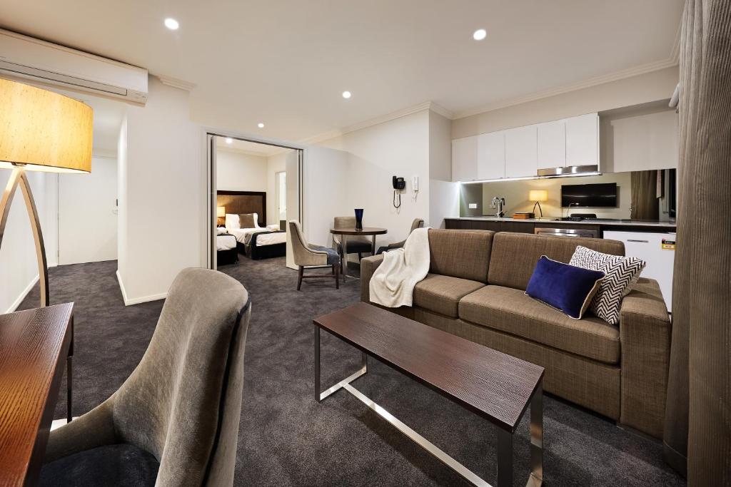 a living room filled with furniture and a kitchen at Attika Hotel in Perth