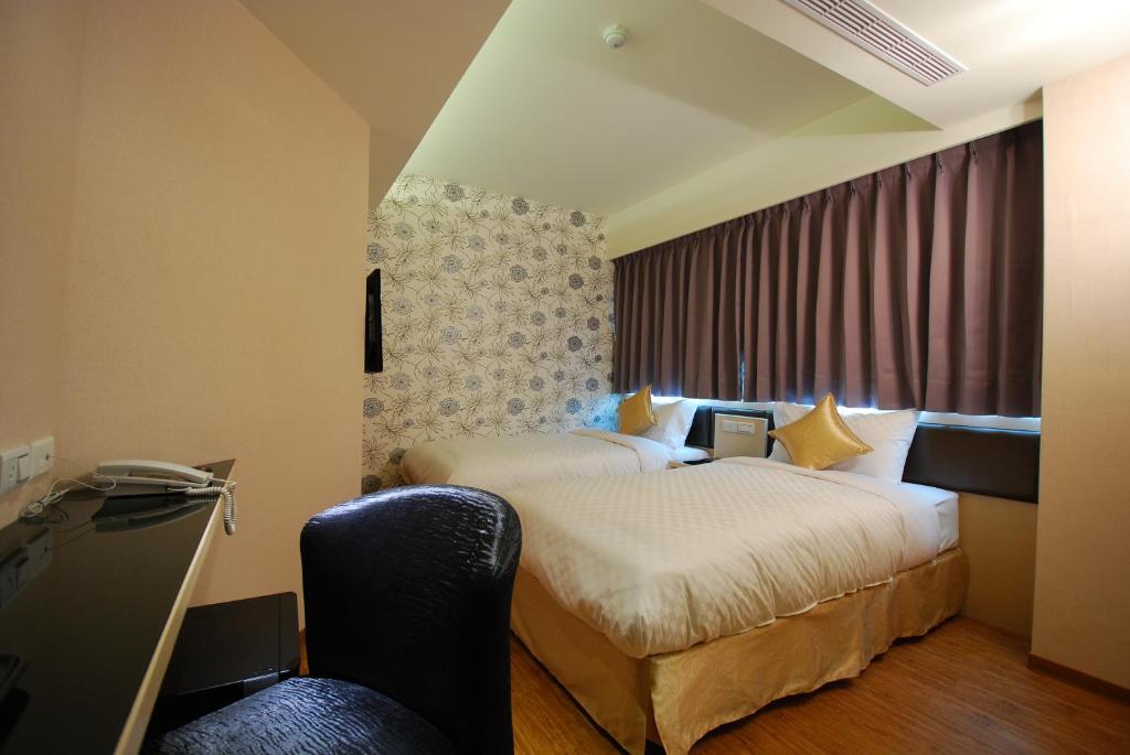Habitación de hotel con 2 camas y escritorio en 欣欣旅店, en Taipéi