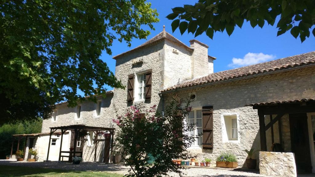 un ancien bâtiment en pierre avec une tour dans l'établissement Cottages de Garrigue, à Fonroque