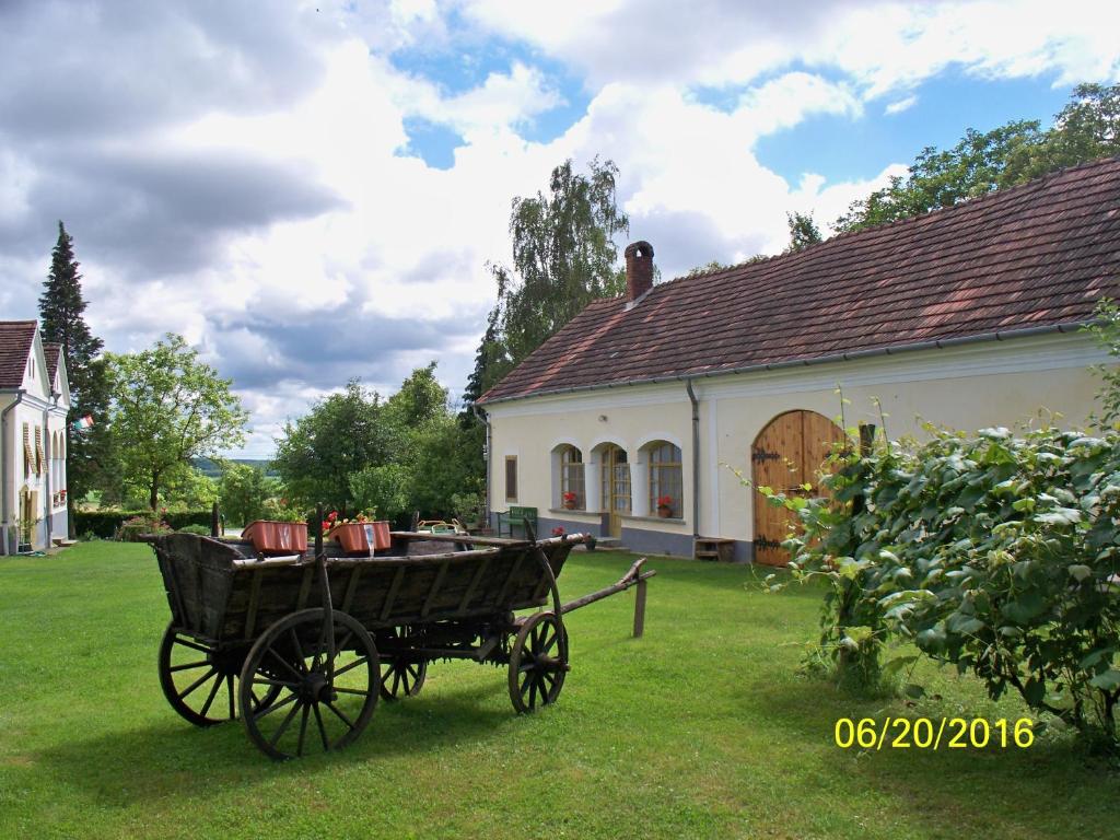 un carruaje de madera frente a una casa en Molnárporta, en Szentgyörgyvölgy