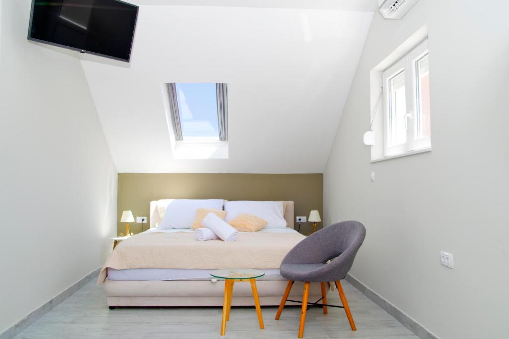een slaapkamer met een bed en een stoel en een tv bij Split Center in Split