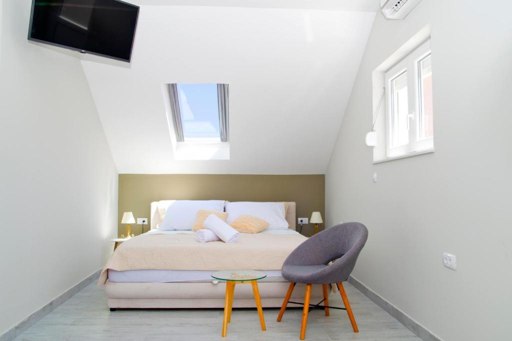 a bedroom with a bed and a chair and a tv at Split Center in Split