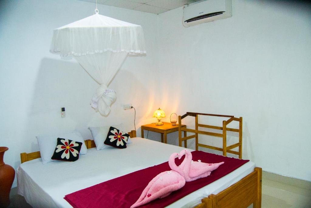 - une chambre avec un lit et 2 flamants roses dans l'établissement Sigiri Lodge, à Sigirîya