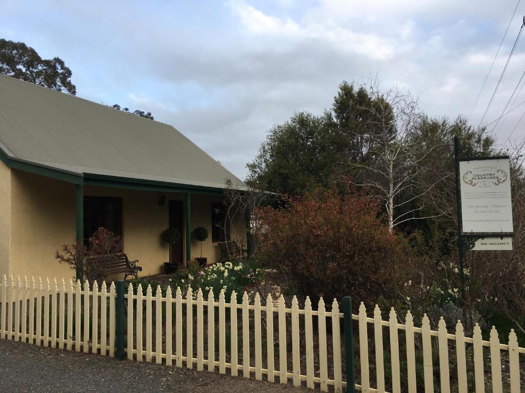 uma cerca branca em frente a uma casa em Country Pleasures Bed and Breakfast em Angaston