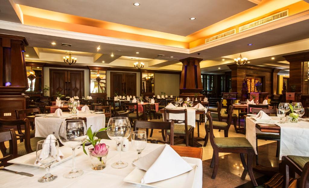 a dining room with white tables and chairs at Prince Angkor Hotel & Spa in Siem Reap