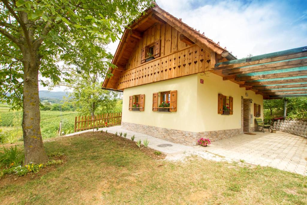 une petite maison avec un toit en bois dans l'établissement Country House Srček with Two Bedrooms and Vineyard View, à Bizeljsko