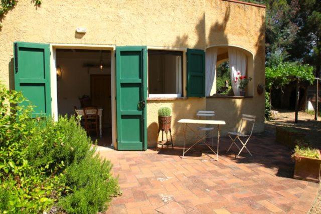 カスタニェート・カルドゥッチにあるPodere Uccellieraの緑のドアとテーブルのあるパティオ