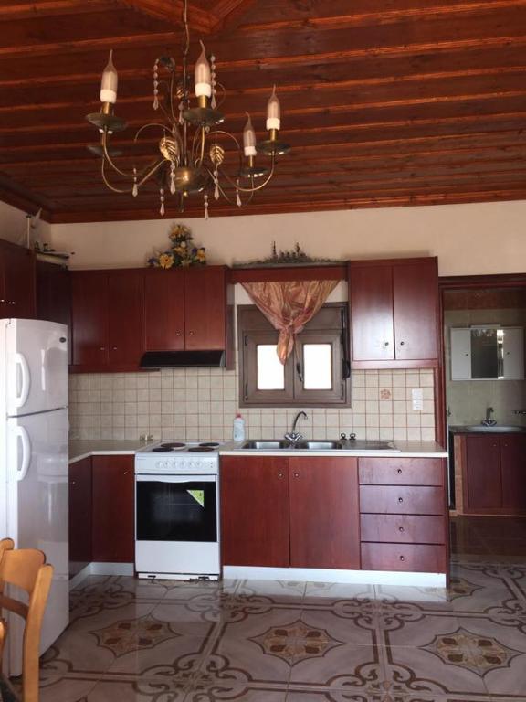 a kitchen with wooden cabinets and a chandelier at Princess Studios in Afiartis