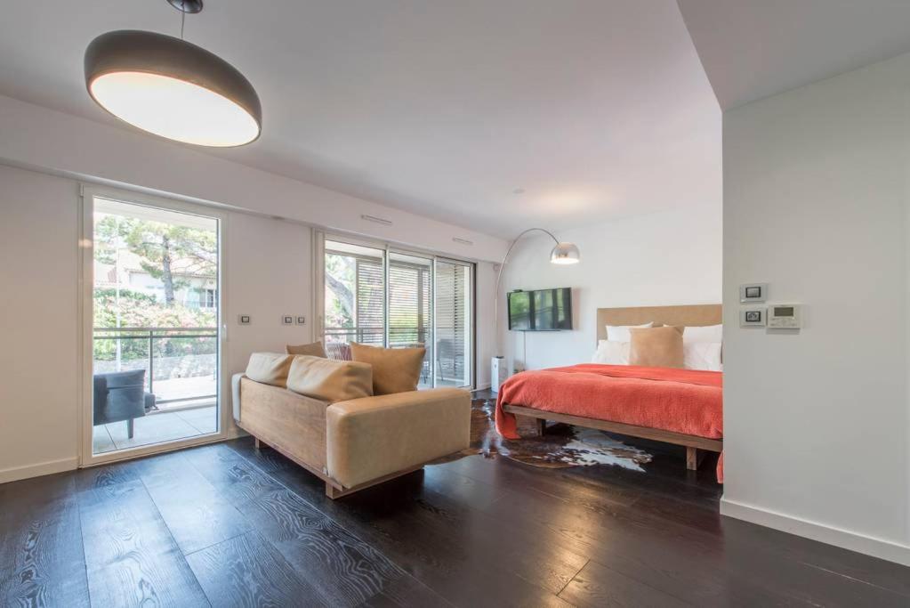 サントロペにあるTropezienne Deluxe Apartmentのベッドルーム1室(ベッド1台、ソファ、椅子付)