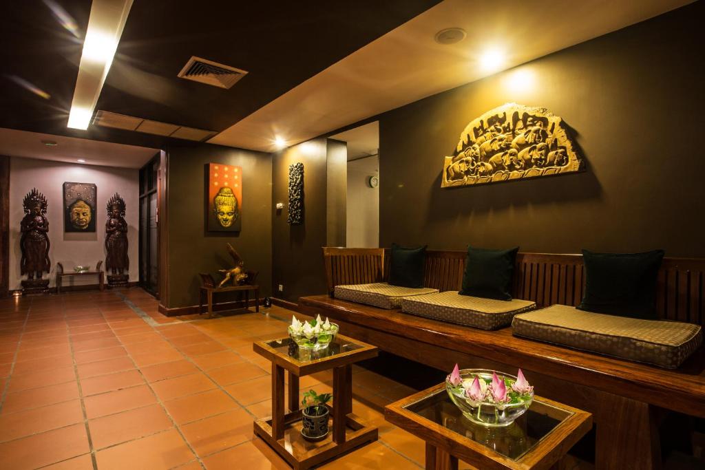 a waiting room with benches and paintings on the wall at Prince Angkor Hotel & Spa in Siem Reap