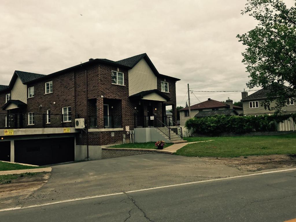 a brick house with a garage on a street at Luxury Two Story Villa Unit C in Laval
