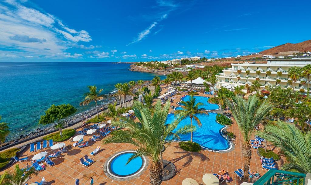 einem Luftblick auf ein Resort mit Pool und Meer in der Unterkunft Hipotels Natura Palace Adults Only in Playa Blanca