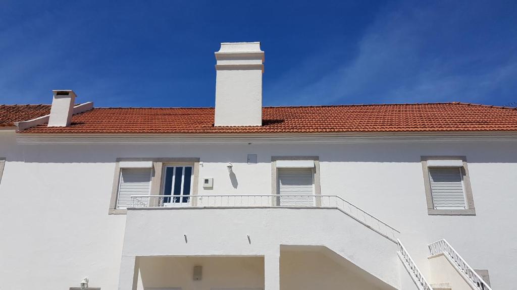 a white building with a chimney and a balcony at Villa Mucifal D in Sintra