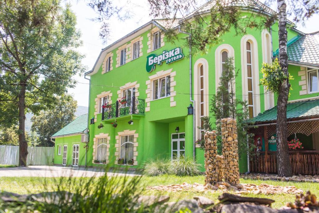 un edificio verde con un cartel. en Berizka, en Perechin