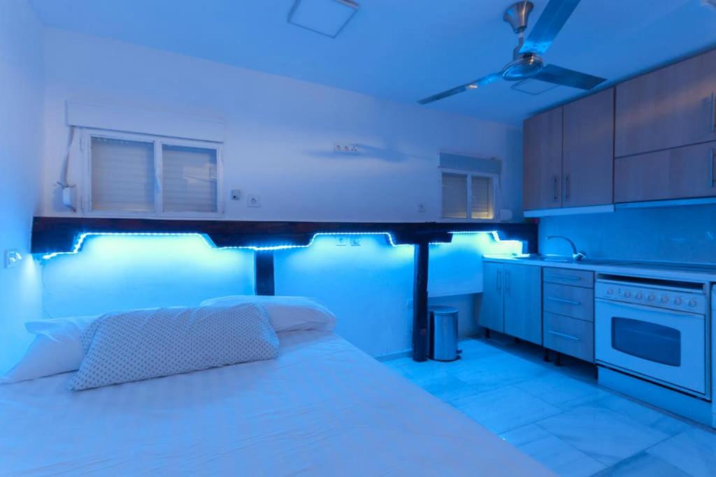 cocina con cama en una habitación con iluminación azul en Mendez Alvaro ATOCHA, en Madrid