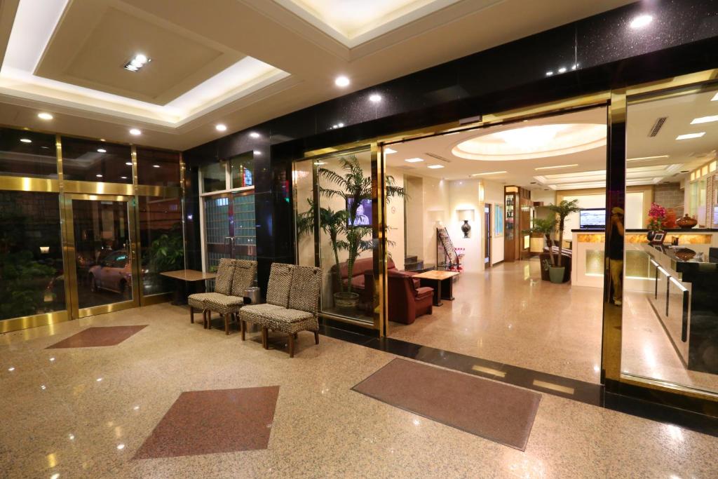 a lobby with chairs and tables in a building at Kai Fu Hotel in Taoyuan