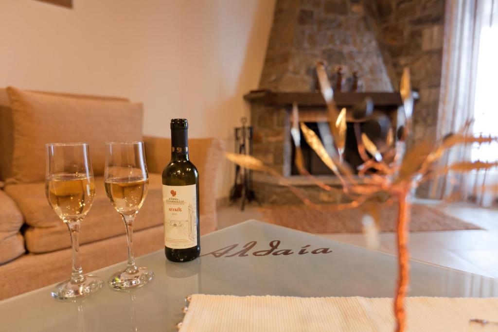 una botella de vino sentada en una mesa con dos copas de vino en Althaia, en Ano Chora