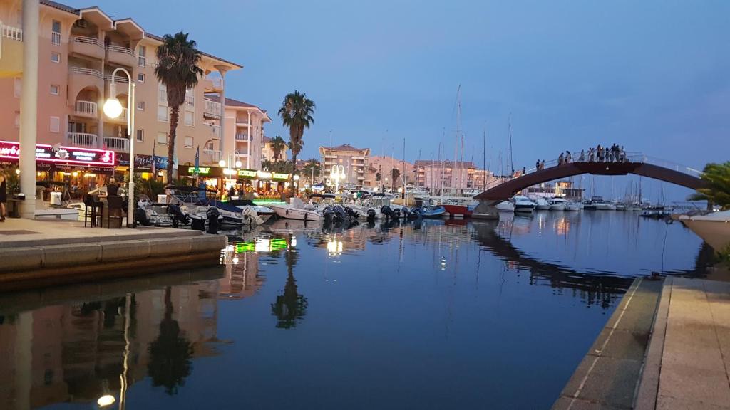 une rivière avec des bateaux dans une ville la nuit dans l'établissement La Villa Fréjus-Plage, à Fréjus