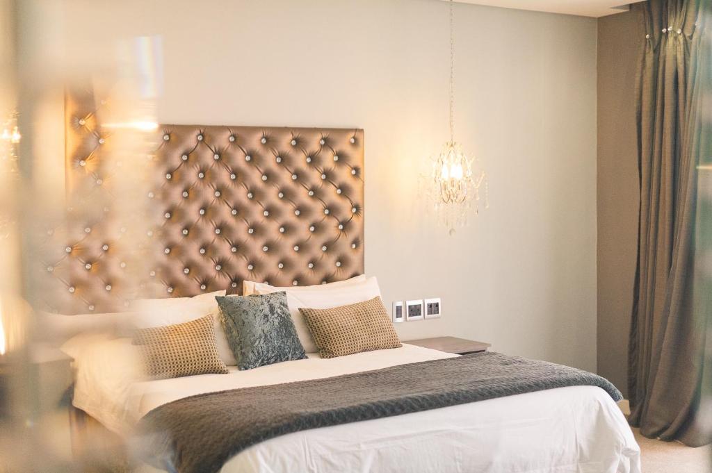 Un dormitorio con una cama grande y una lámpara de araña. en Blue Diamond Boutique Hotel, en Pretoria