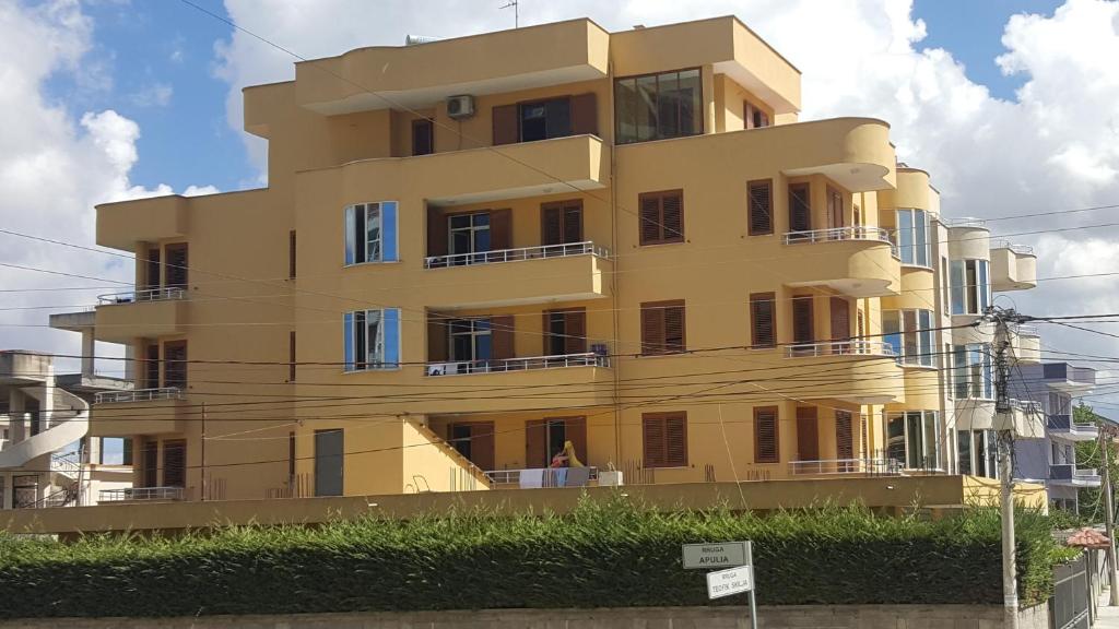 a yellow building with windows and balconies at Apartments Vila Cala in Durrës