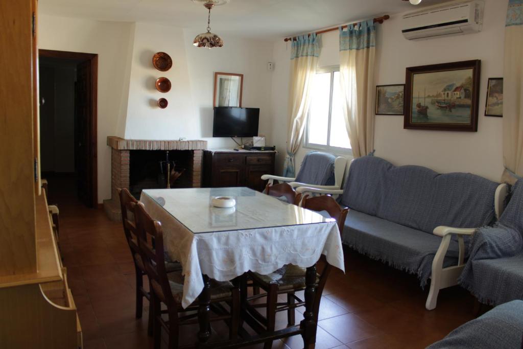 sala de estar con mesa y sofá en Casa Rural El Tejar, en Higuera de la Sierra