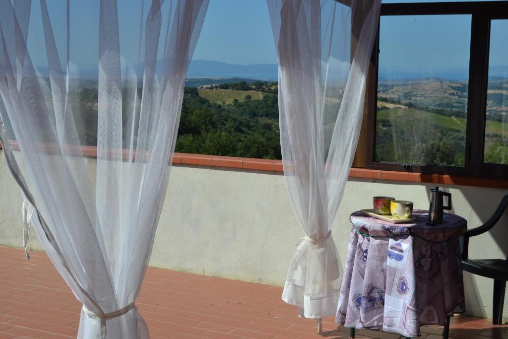 a room with curtains and a table and a window at Appartamento panoramico in Pancole